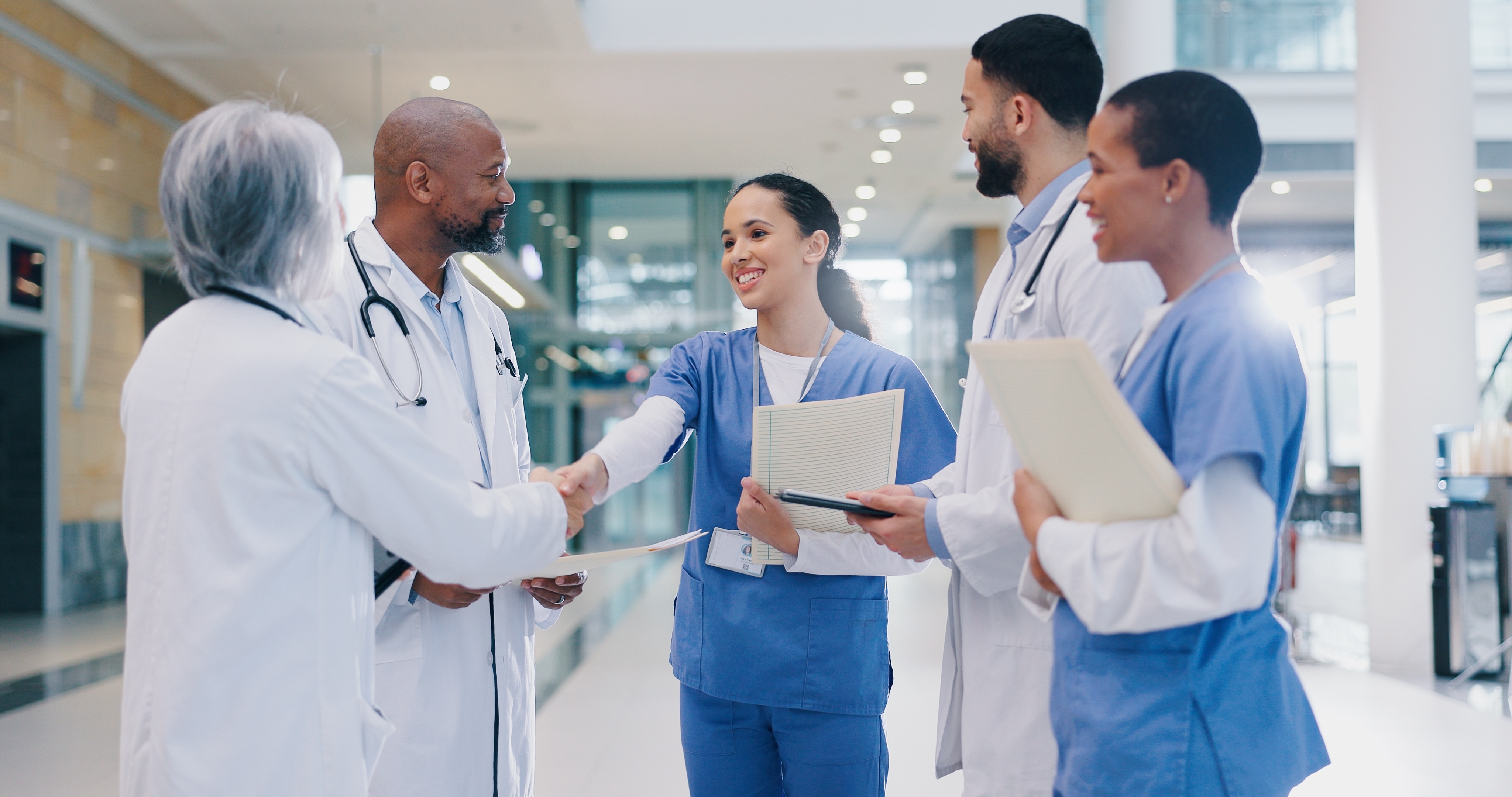 diverse group of clinicians gathering in a hospital hallway